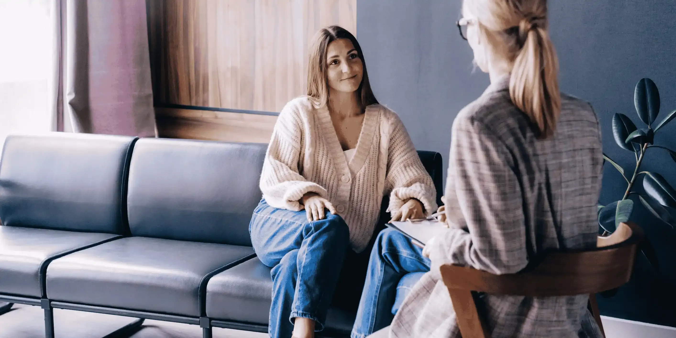 Young woman smiles at therapist during a counseling or consultation session.